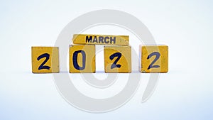 Wooden block calendar for March 2022. Yellow on a white background