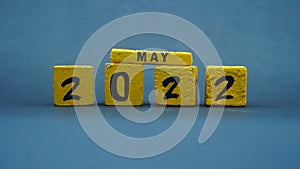 Wooden block calendar for May 2022. Yellow on a dark background