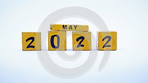 Wooden block calendar for May 2022. Yellow on a white background