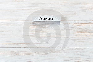 Wooden block of calendar with month August on wood background