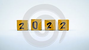 Wooden block calendar with numbers for 2022. Yellow on a white background