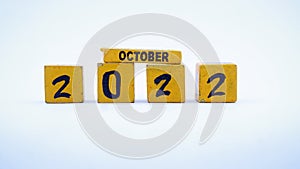 Wooden block calendar for October 2022. Yellow on a white background