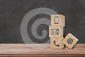 wooden block cube with telephone, email, address icon.