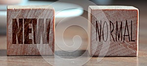 Wooden block cubes for new normal wording. The world is changing to balance it into new normal include business