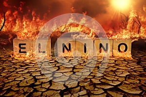 Wooden block of El Nino on cracked mud and wild fire background. climate change and global warming concept