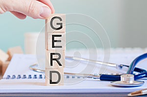 Wooden block form the word gerd with stethoscope on the doctor`s desktop, medical concept