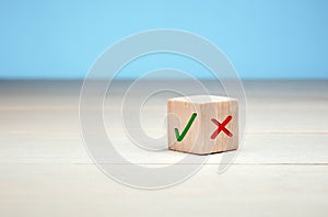 Wooden block with green check mark and red x. Choice and decision making concept.