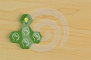 Wooden block with human heads and light symbol. Creative idea and innovation concept