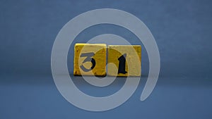 Wooden block with number 31. Yellow color on dark background