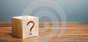 Wooden block with a question mark. Asking questions, searching for truth. Riddle mystery, investigation and research. FAQ -