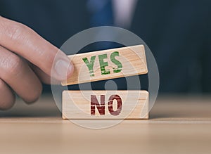 The wooden block shows yes or no letters. The concept of making decisions, voting, and thinking right and wrong. Business options