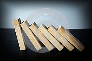 A wooden block stops the fall of other parts of the domino effect.