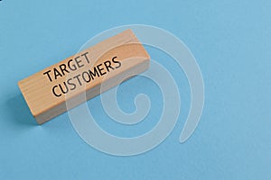 Wooden block with text TARGET CUSTOMERS isolated on a blue background