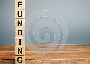 Wooden block with the word Funding. The concept of providing financial resources to organizations and enterprises. Credit, photo