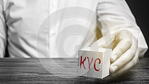 Wooden block with the word KYC - Know Your Customer / Client. Verify the identity, suitability and risks involved with maintaining