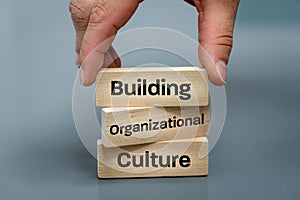 A wooden block with the words Building, Organizational, Culture, Modern approach to working with people in a team, Creative