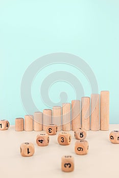 Wooden blocks as increasing graph bar. Dice stack on white table. Concept for business risk, chance, or growth.