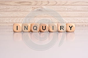 wooden blocks displaying the word 'Inquiry' arranged on a glossy gray surface photo
