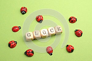 Wooden blocks with German word luck on a green background