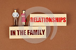 On wooden blocks with the inscription - Relationships in the family, there are miniature figures of people.