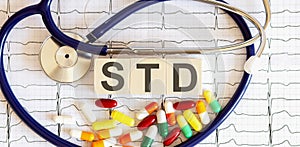 Wooden blocks with the inscription STD with a stethoscope,pills