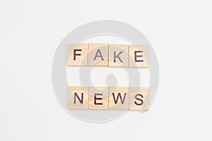 Wooden blocks with letters FAKE NEWS on white baclground