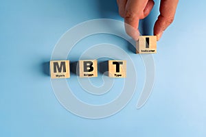 Wooden blocks with the letters MBTI on blue background. Personality typology. Psychology test for human types.MBTI - Myers-Briggs