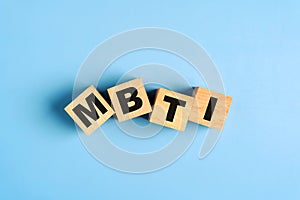 Wooden blocks with the letters MBTI on blue background. Personality typology. Psychology test for human types.MBTI - Myers-Briggs