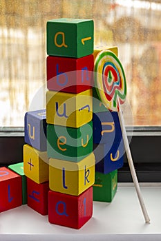 Wooden blocks with letters and numbers and a lollypop photo