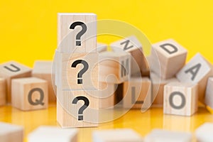 wooden blocks with lhe three question marks, concept photo