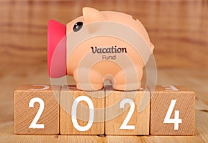 Wooden blocks lined up with the letters 2024 with piggy bank concept of saving