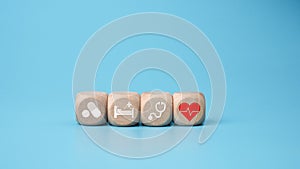 Wooden blocks with medical symbol icons on blue background representing health concept with treatment and medicine