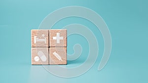 Wooden blocks with medical symbol icons on blue background representing health concept with treatment and medicine