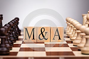 Wooden Blocks With Mergers And Acquisitions Text On Chess Board