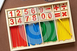 Wooden blocks with numbers on brown background. Set for studying mathematics on the table. Education, back to school concept.