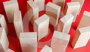 Wooden blocks on a red background. The concept of a labyrinth of wardrobes or dense urban construction. Barriers and obstacles