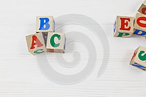 Wooden blocks spell out ABC on the wooden table. Games and tools for kids in preschool or daycare. Education, back to school