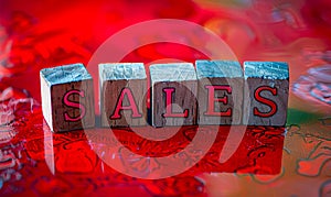 Wooden blocks spelling out SALES on a vibrant red background, representing business marketing, retail promotions, and commercial