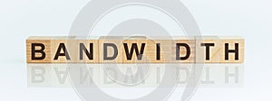 Wooden Blocks with the text: BANDWIDTH. The text is written in black letters and is reflected in the mirror surface of the table