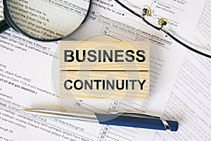 Wooden blocks with text Business Continuity on financial docs