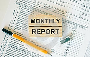 Wooden blocks with text Monthly Report on financial docs