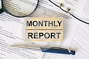 Wooden blocks with text Monthly Report on financial docs