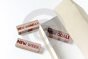 Wooden blocks with text New Monday New Week New Goals in a box on a white background