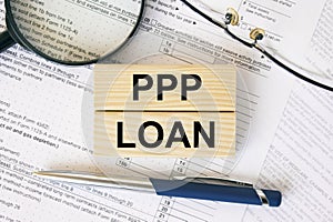 Wooden blocks with text PPP Loan on financial docs