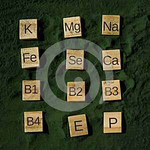 Wooden blocks with text of vitamins in spirulina chlorella algae superfood powder. Vitamin K Mg Na Fe Se Ca B1 B2 B3 B4