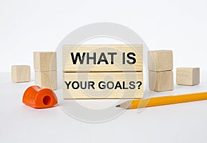 Wooden blocks with text What Is Your Goals with sharpener and pencil