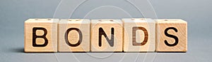 Wooden blocks with the word Bonds. A bond is a security that indicates that the investor has provided a loan to the issuer.