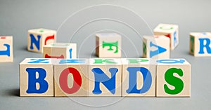 Wooden blocks with the word Bonds. A bond is a security that indicates that the investor has provided a loan to the issuer.