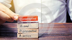 Wooden blocks with the word CAPA. Corrective and Preventive action plans. Business management concept. Strategy and efficiency.