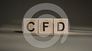 A wooden blocks with the word CFD - Contract For Difference, written on it on a gray background